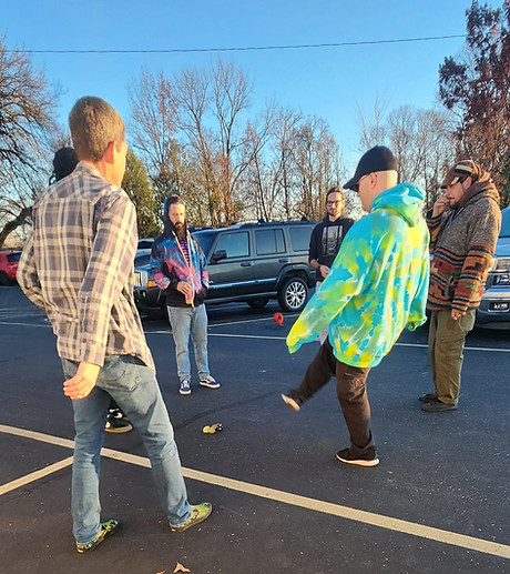 A group playing hackysack in a parking lot