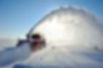 Snow removal worker using a powerful snow blower to clear a residential driveway and sidewalk after a heavy overnight snowfall