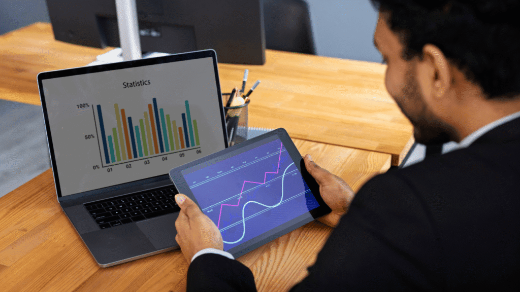 Man analyzing program data on tablet and laptop