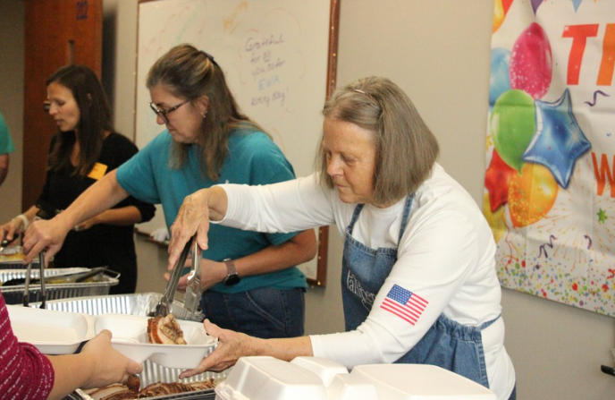 Parent volunteers assist in serving the staff Prime Barbecue for lunch.