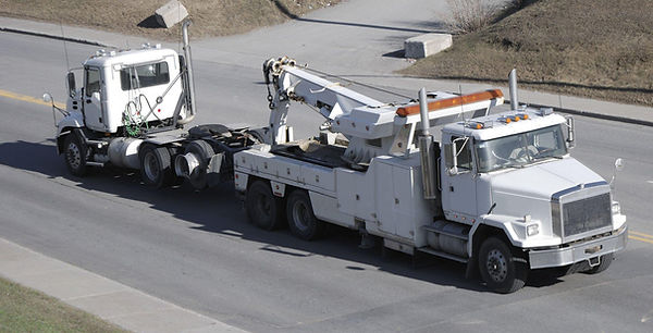 semi truck being towed by wrecker