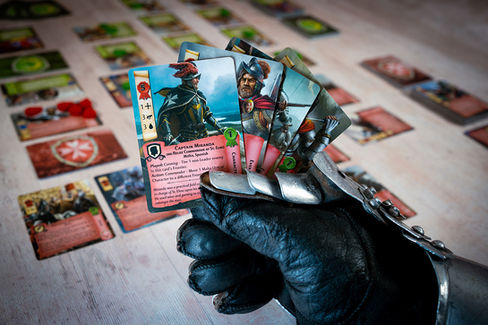 A gloved hand holding a hand of cards