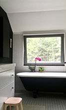 salle de bain noire et blanche.Céramique à carreaux blancs 2x2.
Baignoire sur pattes noire et blanche. Plancher en mosaïque.
