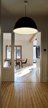 lampe suspendue design. parquet en bois . poutre apparente. Moulure porte