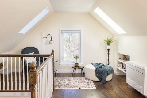 Medford MA attic converted into open living space with skylights, custom railing, and hardwood floors by Morse Constructions