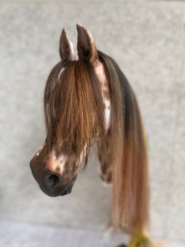 Handmade Appaloosa hobby horse with long flowing brown mane covering the face.