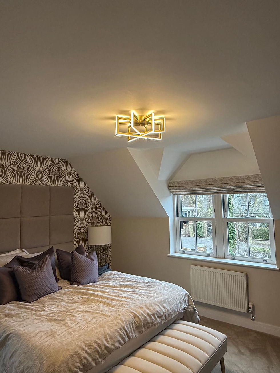 Geometric gold flush ceiling light in a loft bedroom, Berkshire