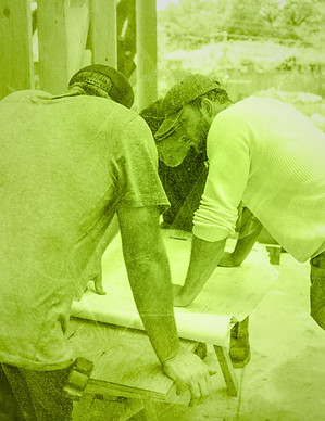 Two contractors analyzing project blueprints on a construction job site for streamlined scheduling.