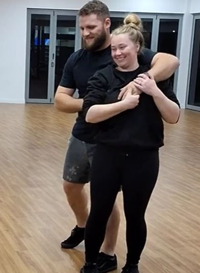 Couple learning beginner wedding dance turns.
