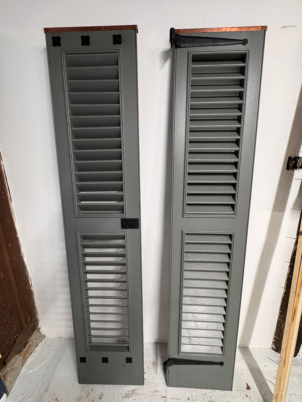 Restored wood shutters with copper caps and black hardware