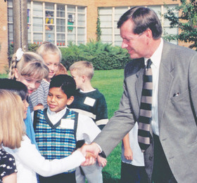 Mike Leavitt shakes students hand
