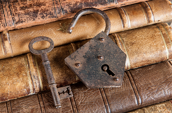Open lock and key on book spines