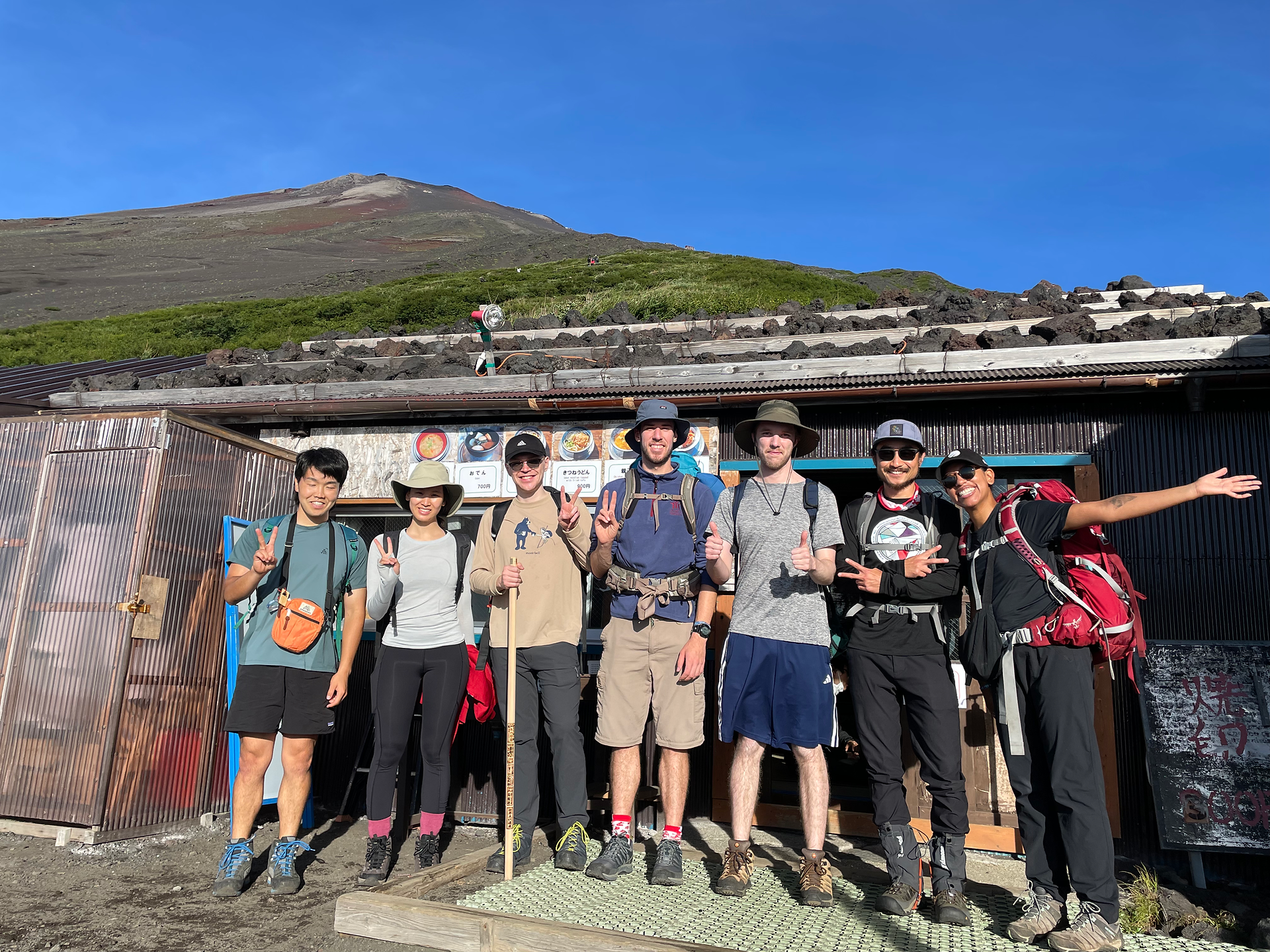 Group of friends in front of a 6th station mountain hut on Mount Fuji preparing for the climb