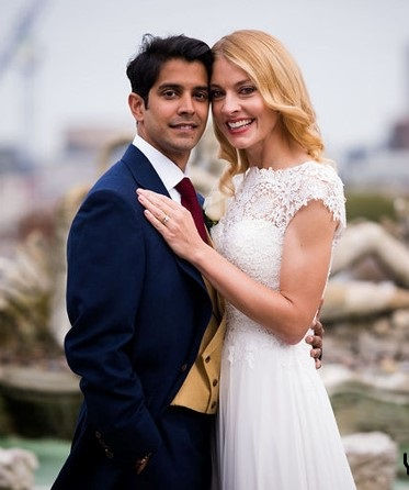 Bride with soft blonde waves and natural bridal makeup beside her groom