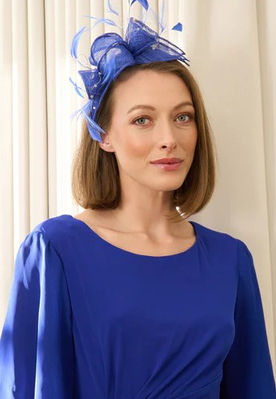 Wedding guest makeup with a sleek bob and a blue fascinator