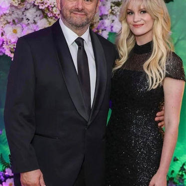 Michael Sheen and Anna Lundberg at a red carpet event, with soft glam makeup and waves