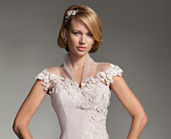 Bride with polished makeup and a sleek side-swept bob with a jewelled hair clip in a blush lace gown