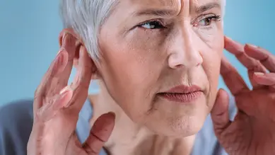 Person confused during a conversation due to hearing clarity issues.