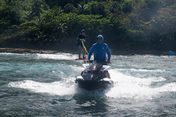Man jetskiing, pulling a hydrofoil rider
