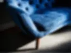 Close-up of a velvet sofa under natural light showing fabric texture and soft reflections.