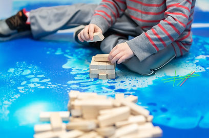 toddler boy on liquid floor tile building with wooden blocks