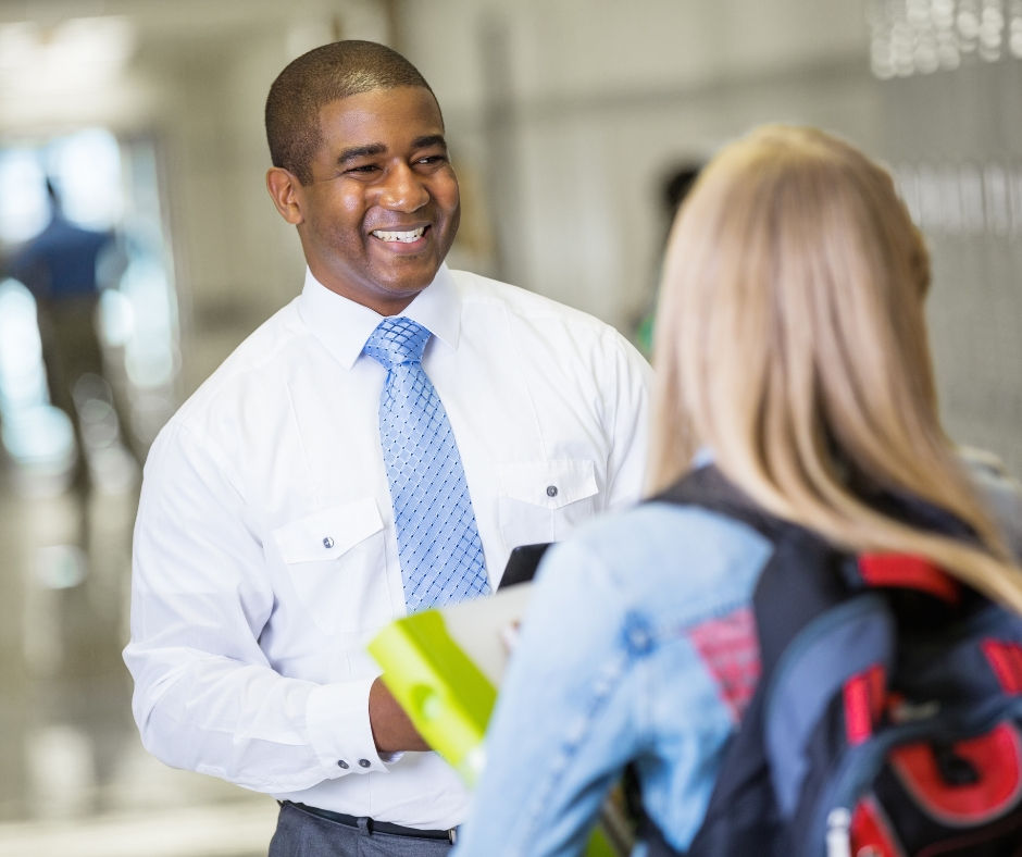 Teacher talking with students in hallway