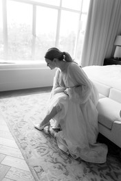 Bride putting her shoe on at savoy hotel wedding