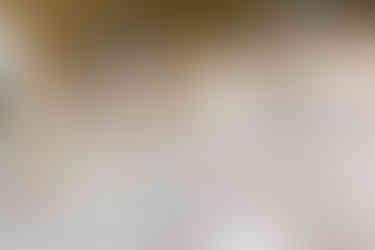 Flowers and candles on table with plates and menu at wedding venue Harlaxton Manor