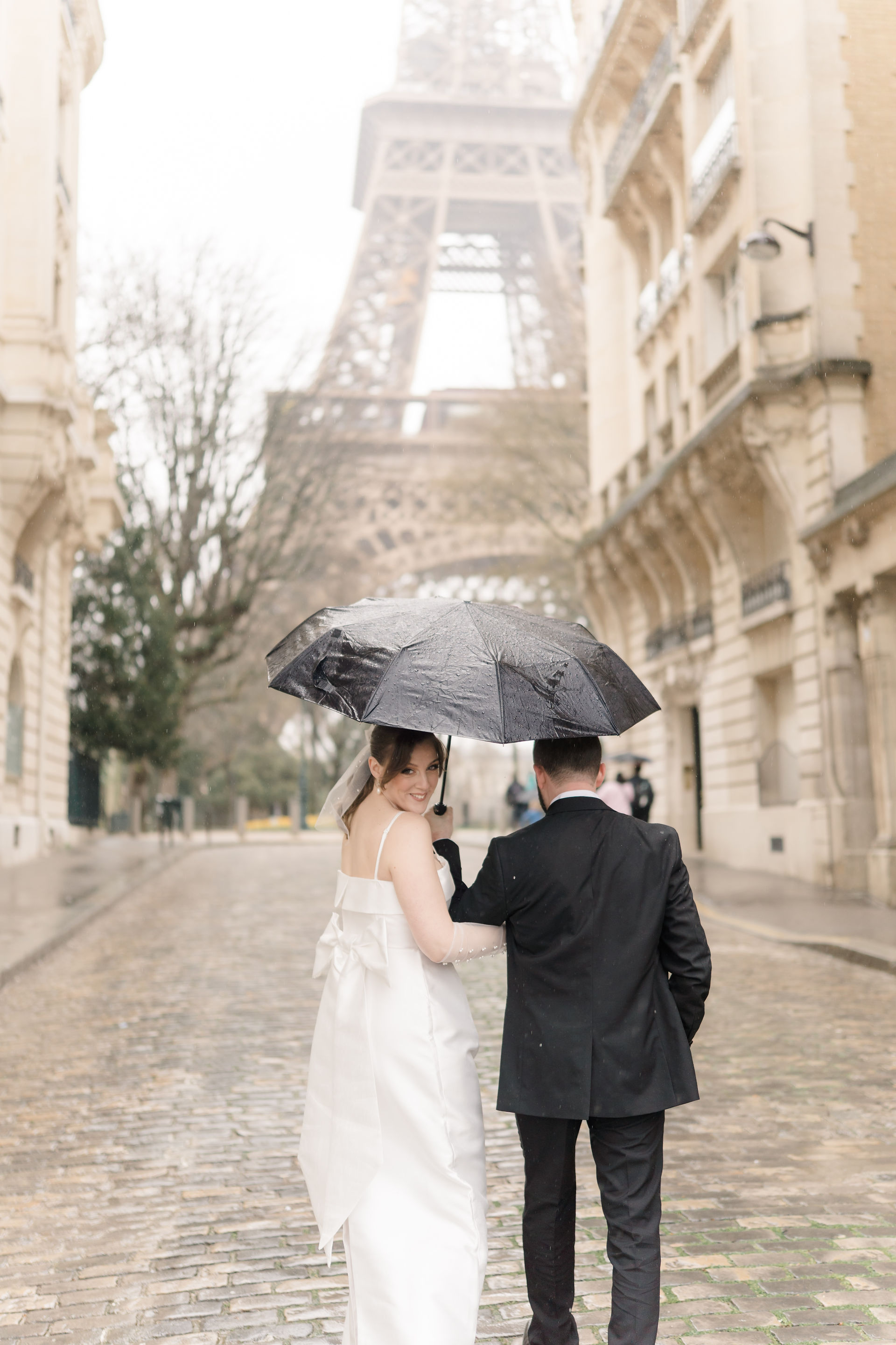 Paris photographer with bride looking over her shoulder back at camera