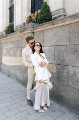 Bride and groom wearing sunglasses holding hands while hugging at Islington town hall wedding