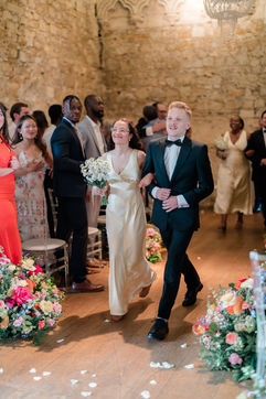 Wedding party linking arms down the isle