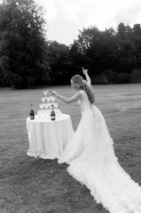 Bride holding glass in front of champagne tower at Avington wedding 