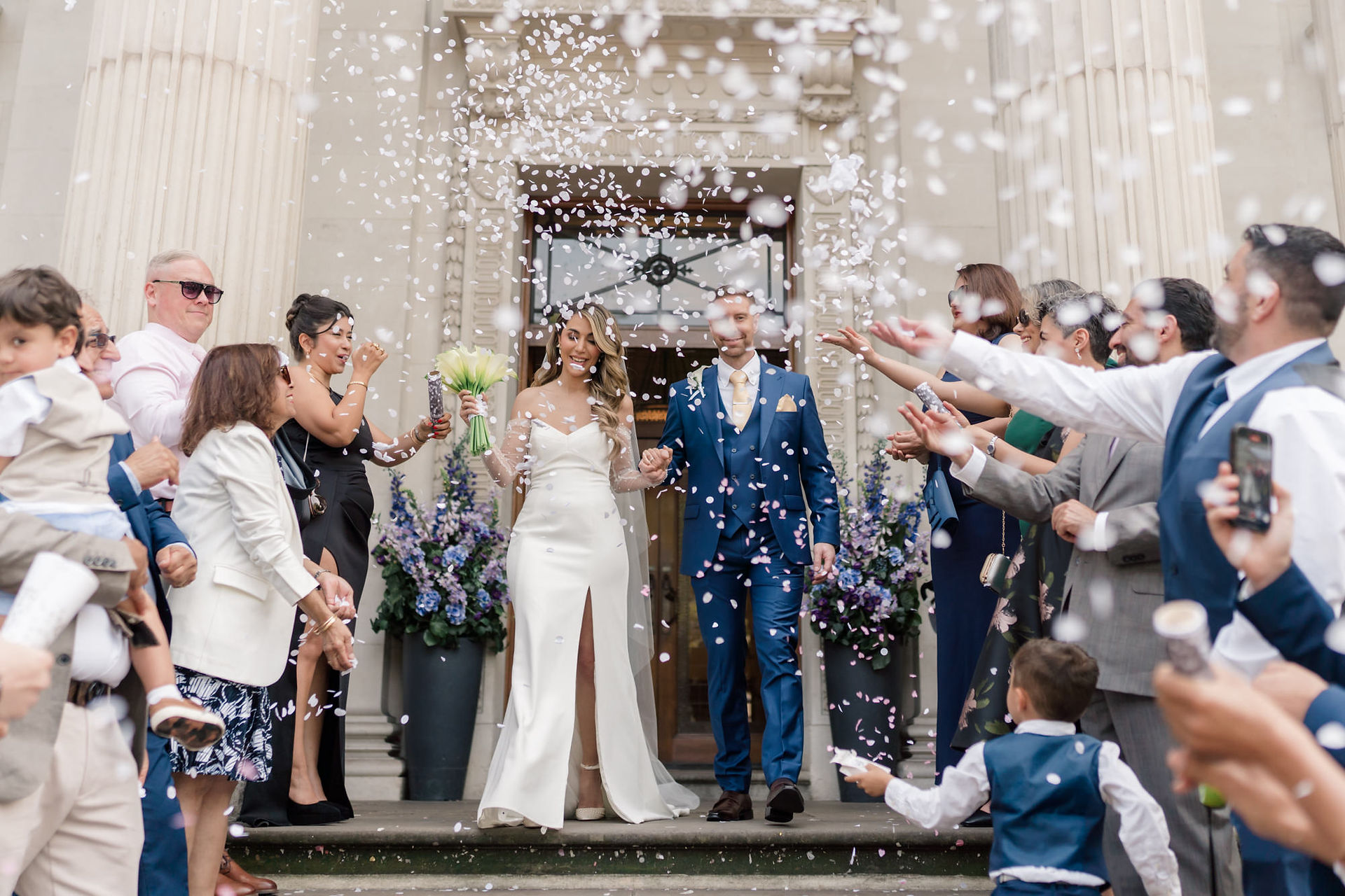 Bride and groom walking through confetti at Marylebone town hall wedding