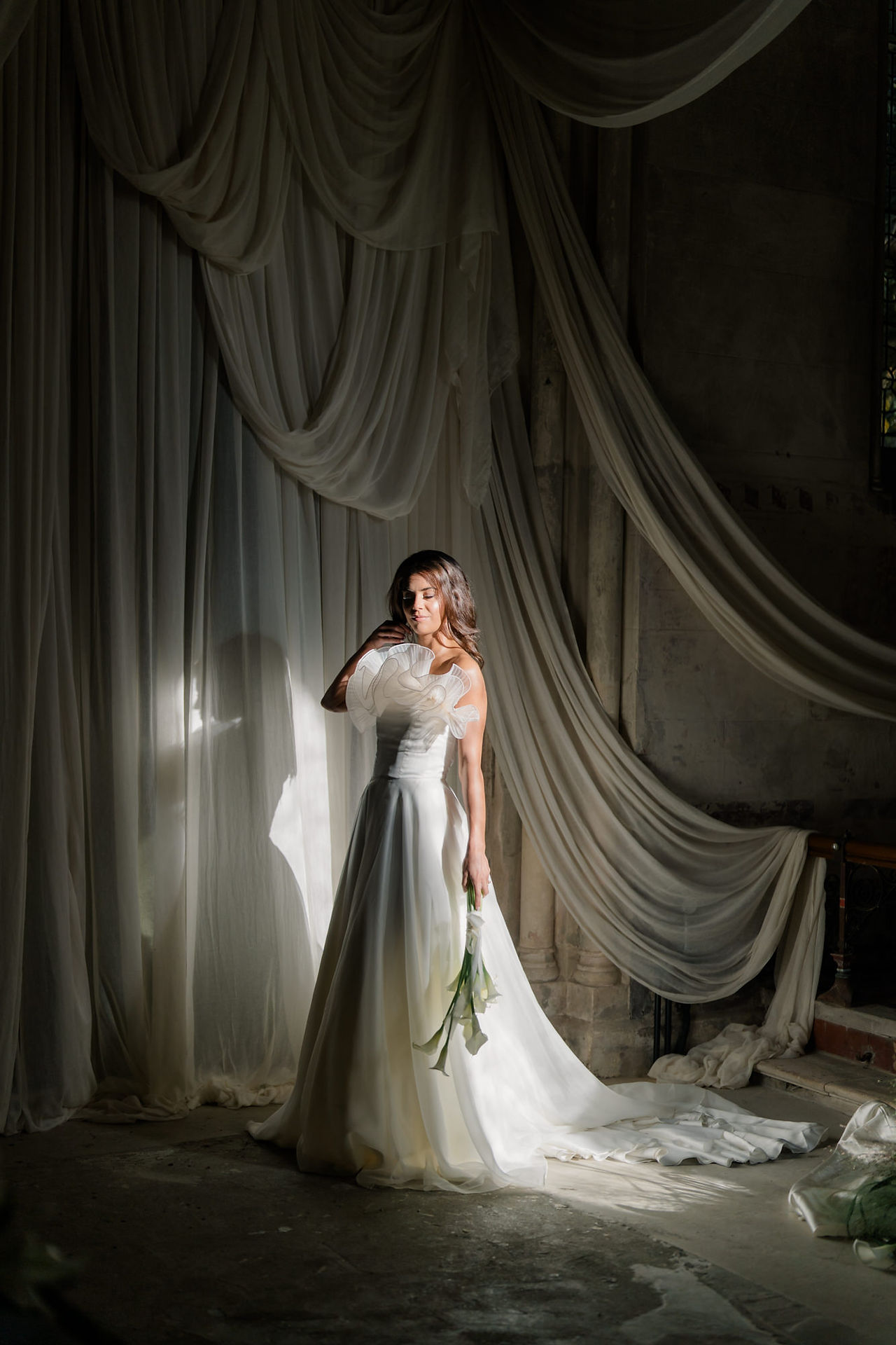 Bride standing in light posing at wedding at Elvetham hotel 