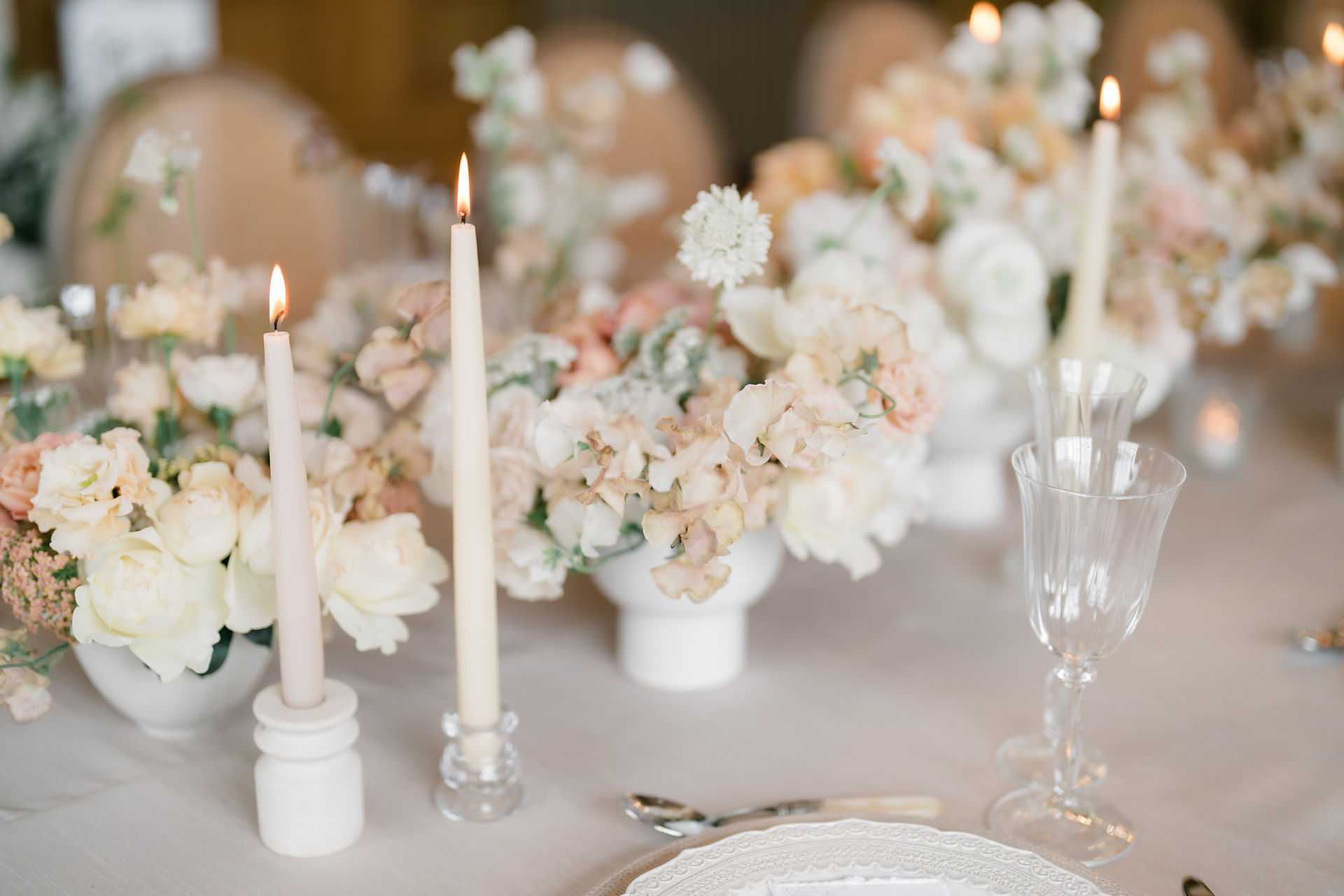 Lit candles and flowers on wedding table at Harlaxton Manor