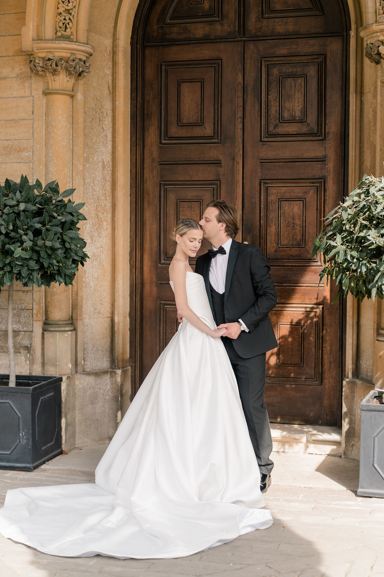 Bride and groom standing outside a door at Grittleton House wedding venue