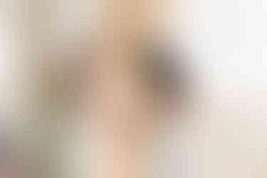 Bridesmaid helping bride put on bracelet at wedding at Rushton Hall