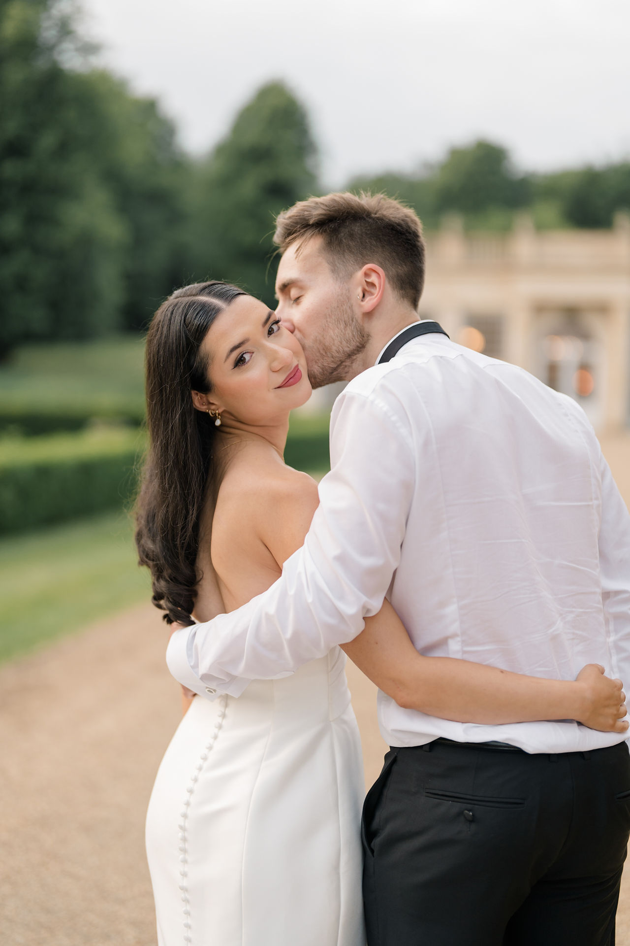 Groom kissing bride on the cheek at Wedding at Rushton hall