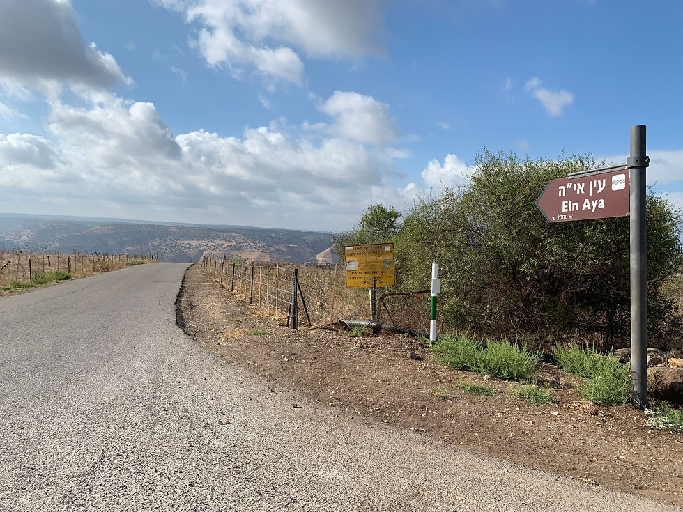 The paved road leading to Ein Aya with a sign on the right with the words "Ein Aya"