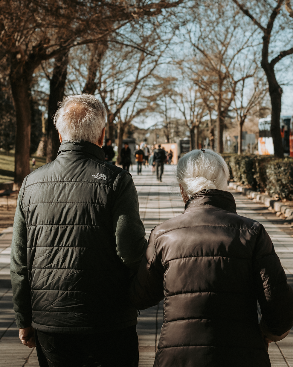Couple de seniors se promenant main dans la main dans un parc ensoleillé