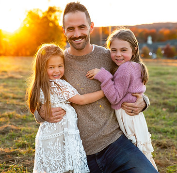 dad holding his daughters in an outdoor CT sunset session