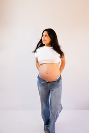 Mom holding pregnant belly at in studio maternity session