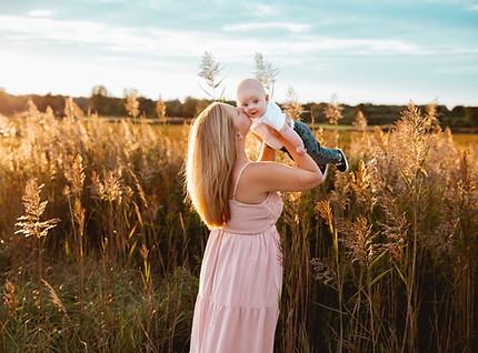 mom holding her baby and kissing him in the air