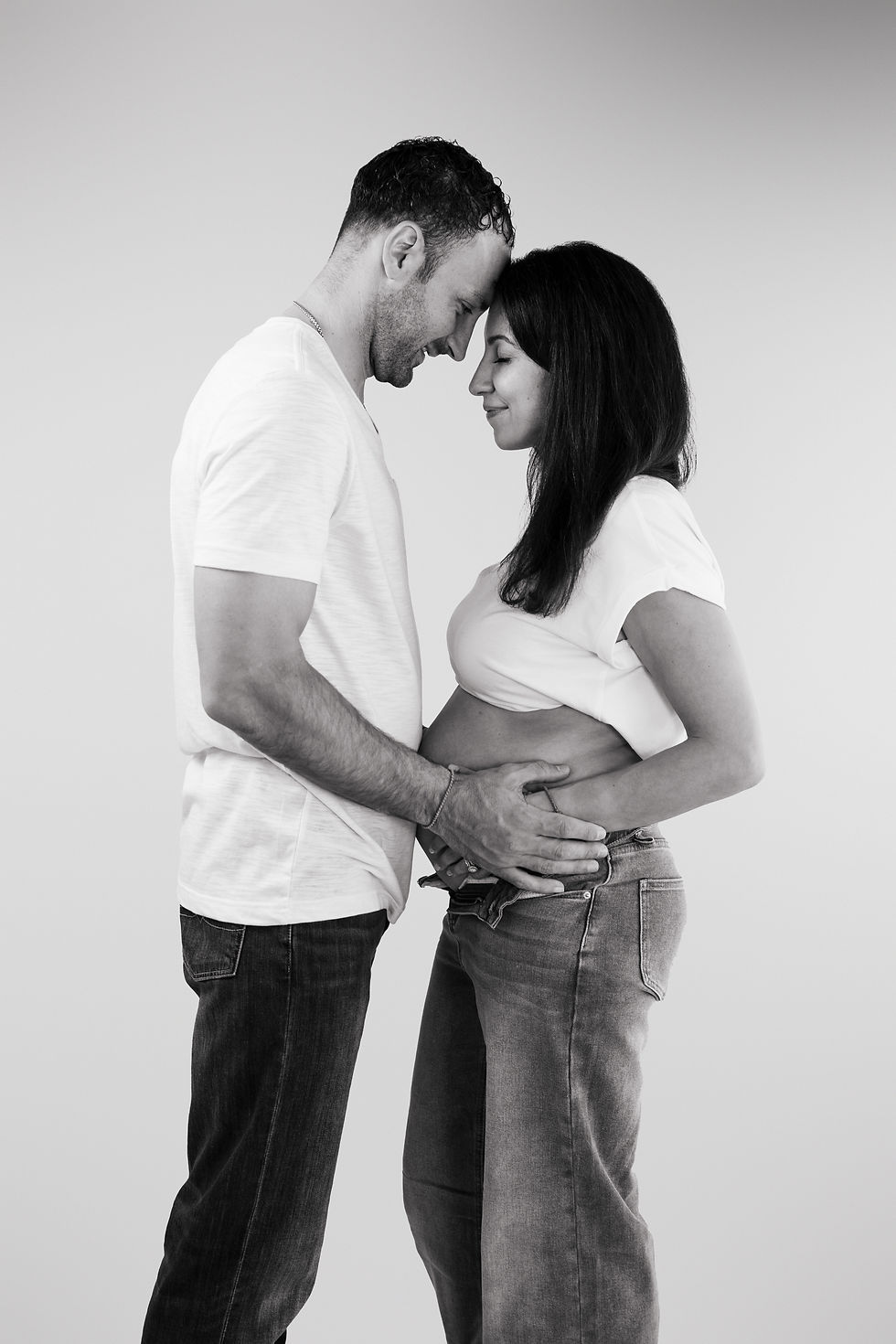 husband and wife embracing at in studio maternity session