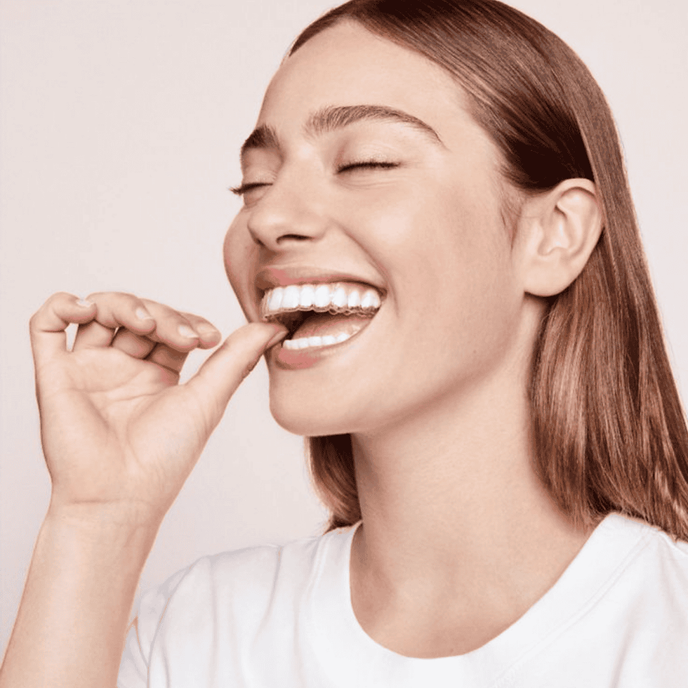 Woman smiling confidently with Invisalign aligners in place.png