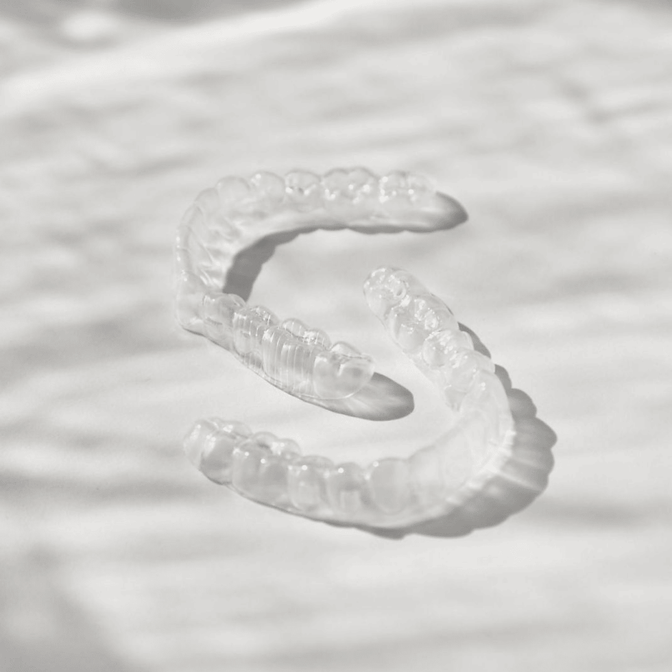 Invisalign clear aligners on teeth close-up.png