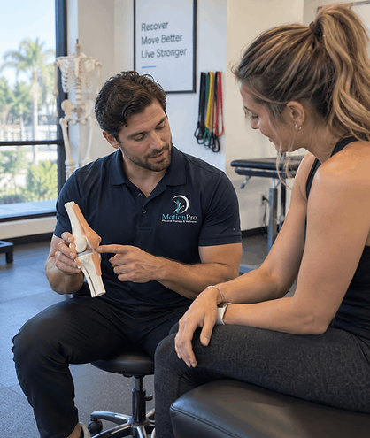 MotionPro physical therapist explaining a knee model and post-surgical rehabilitation plan to a patient in West Palm Beach.