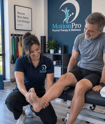 Physical therapist assessing an older male patient’s ankle and foot during a one-on-one rehabilitation session at MotionPro.