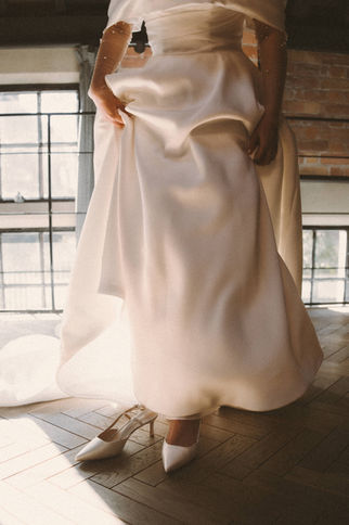 Bridal gown and white wedding shoes in winter sunlight