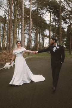 Georgia and Will holding hands among winter trees in Ollerton